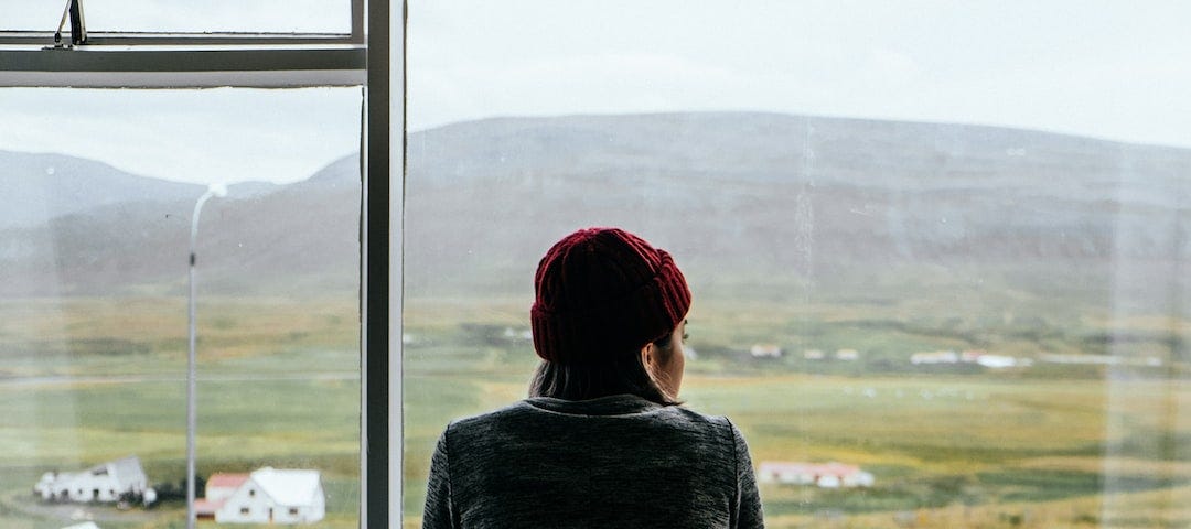 A woman looks out a window.