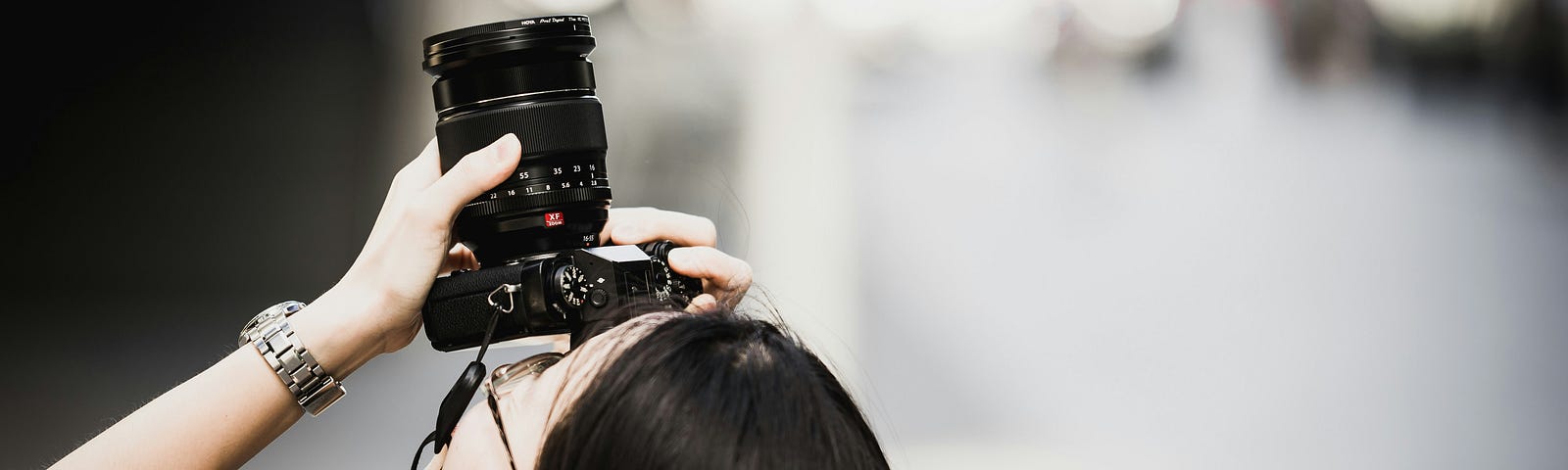 A person focusing a camera lens