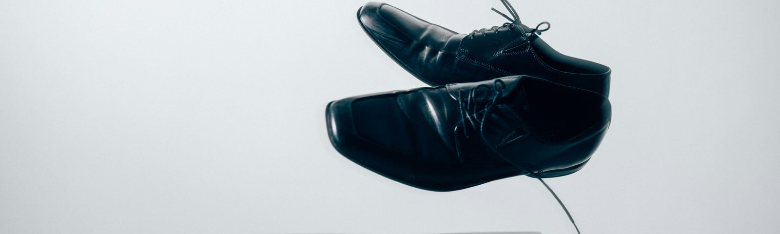 A pair of men’s shoes, floating in mid air above a small table