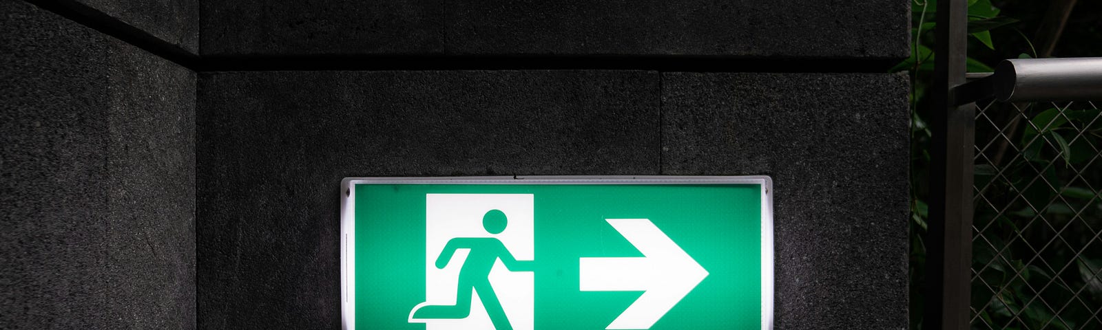 Illuminated exit sign with arrow pointing right.