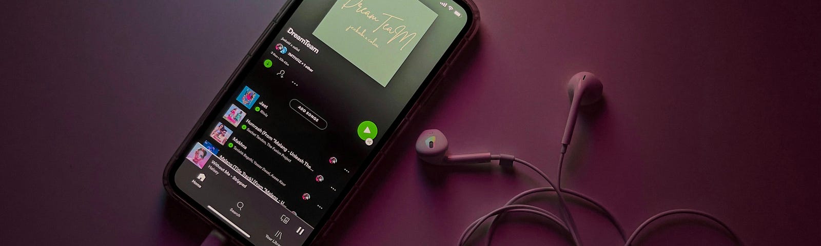 A phone with Spotify open and some earbuds