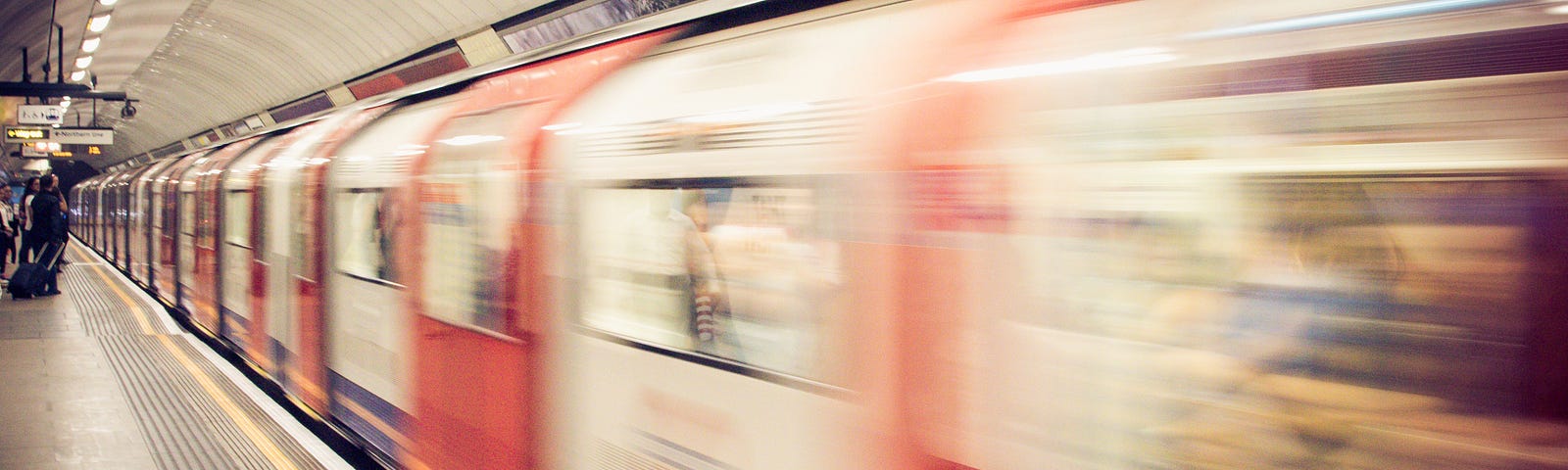 London Underground train speeding along a platform