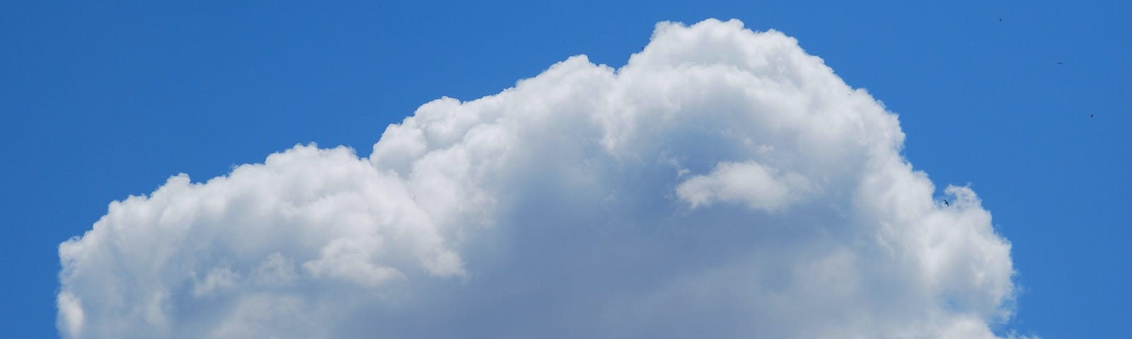 Coloured image showing a fluffy white cloud floating in a clear blue sky