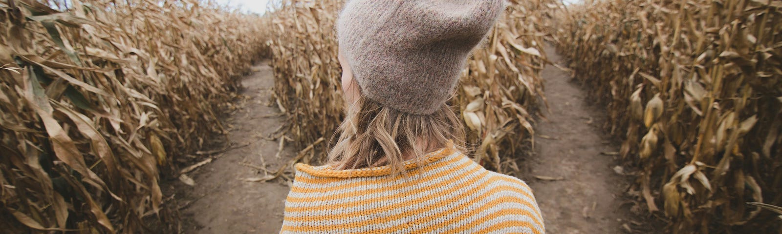 A woman stands at a fork in the path, contemplating which way to go