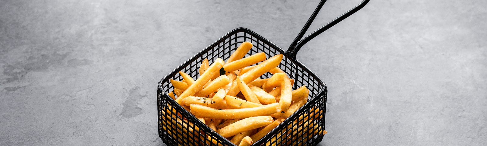 A small black wire fry basket of French fries. Cooking foods at high temperatures is linked to health risks. A new study suggests that high-temperature cooking may damage the food’s DNA. Today we look at red meat and deep-fried food perils.