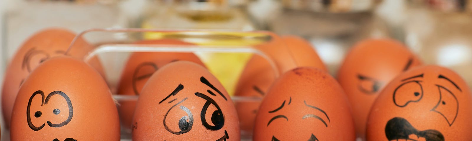 Four eggs with various emotive faces drawn on with sharpie