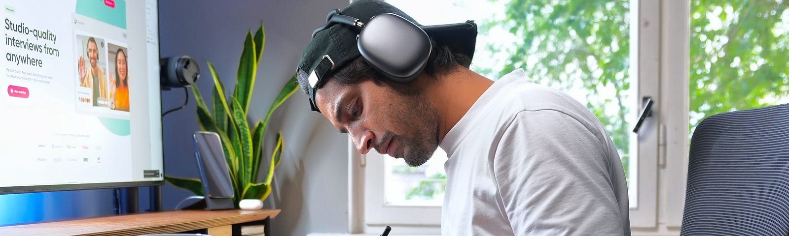 Man sitting at desk working wearing headphones