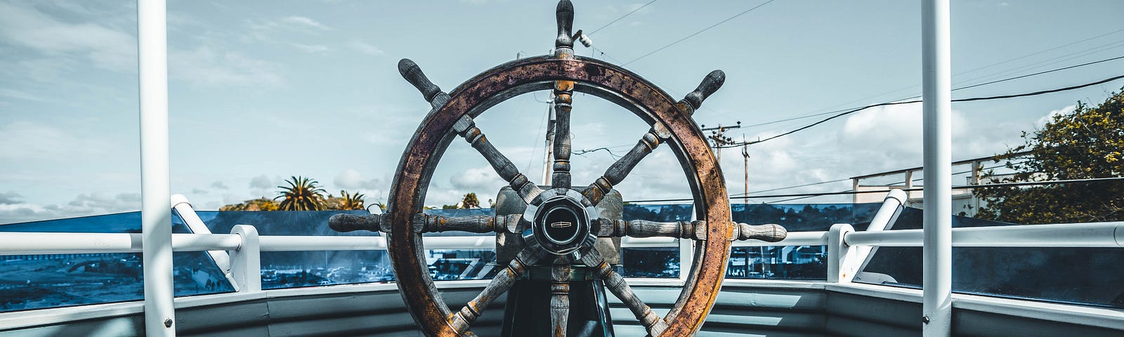 A ship’s wheel stands vacant on a vessel, waiting for guidance of a navigator.