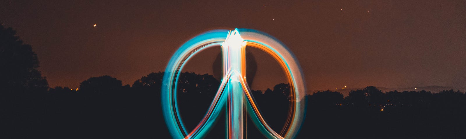 A neon sign-looking image of a peace symbol infront a background of a nighttime scene.