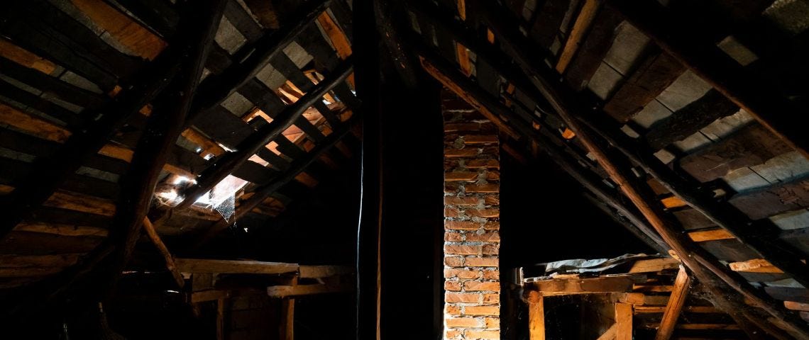 Dark attic with a beam of sunlight illuminating the shadows.