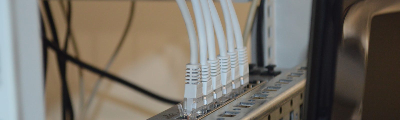 A feature image that shows network cables connected to a device.