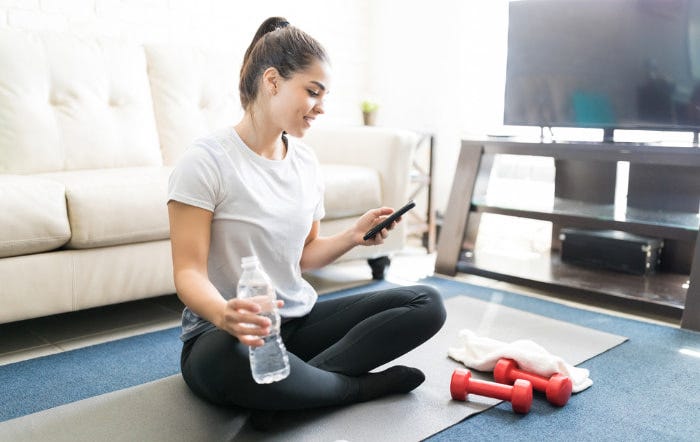 Woman sitting on the floor using fitness app