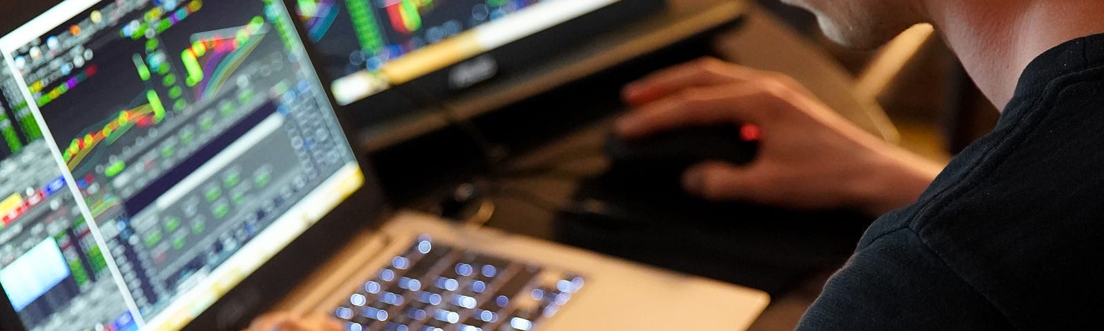 A man looking at screens with stock information