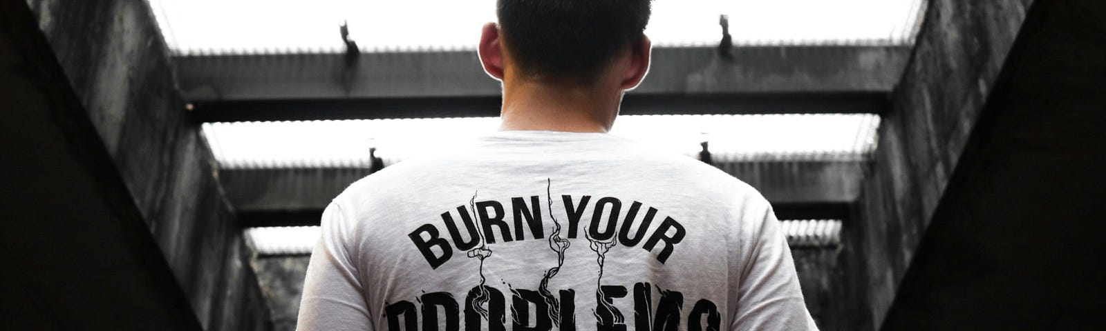 Man wearing a white t-shirt that says “Burn Your Problems”