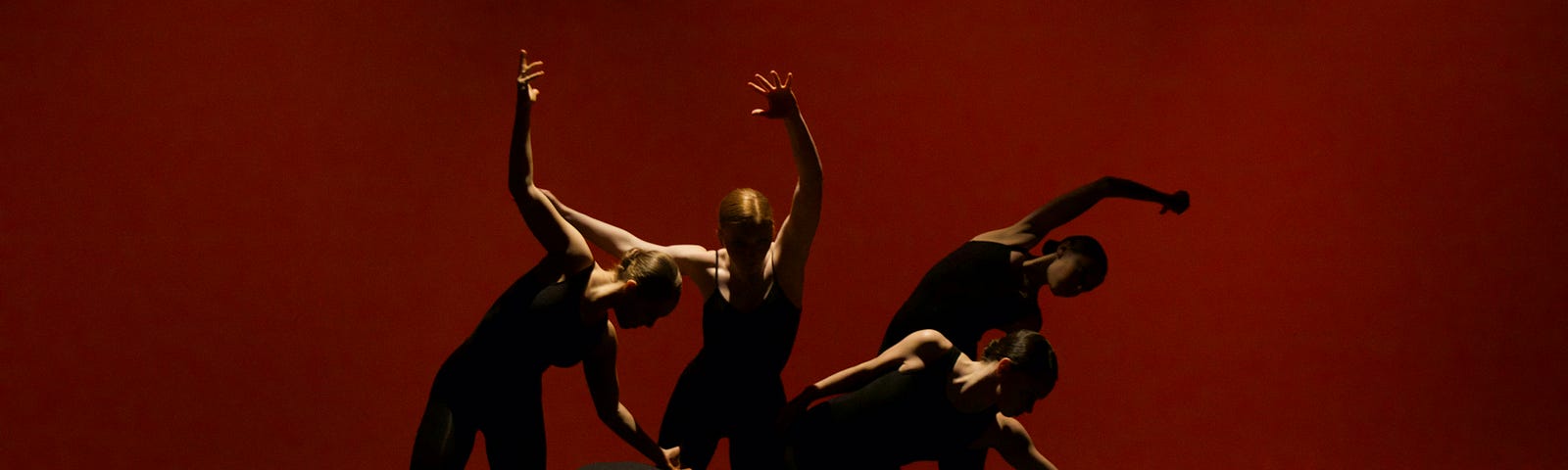 Five muscular actors on a stage, posing dramatically in shadows. Limited light invigorates their poses.