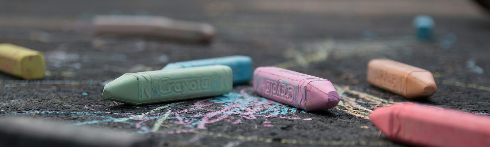 close-up of coloured chalk pencils on pavement