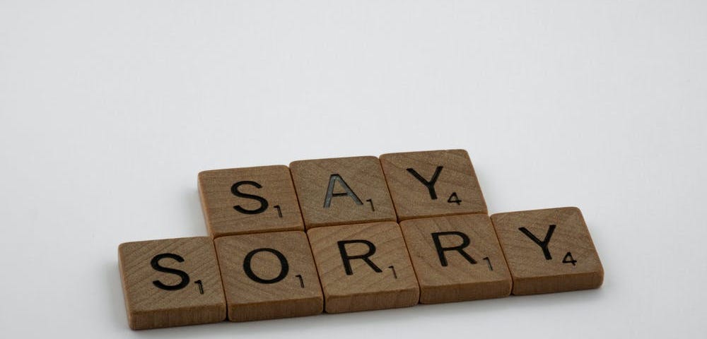 Letter tiles that spell out the phrase, “Say Sorry.”