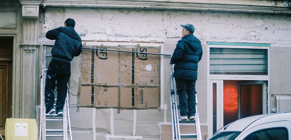 Two people renovating a building