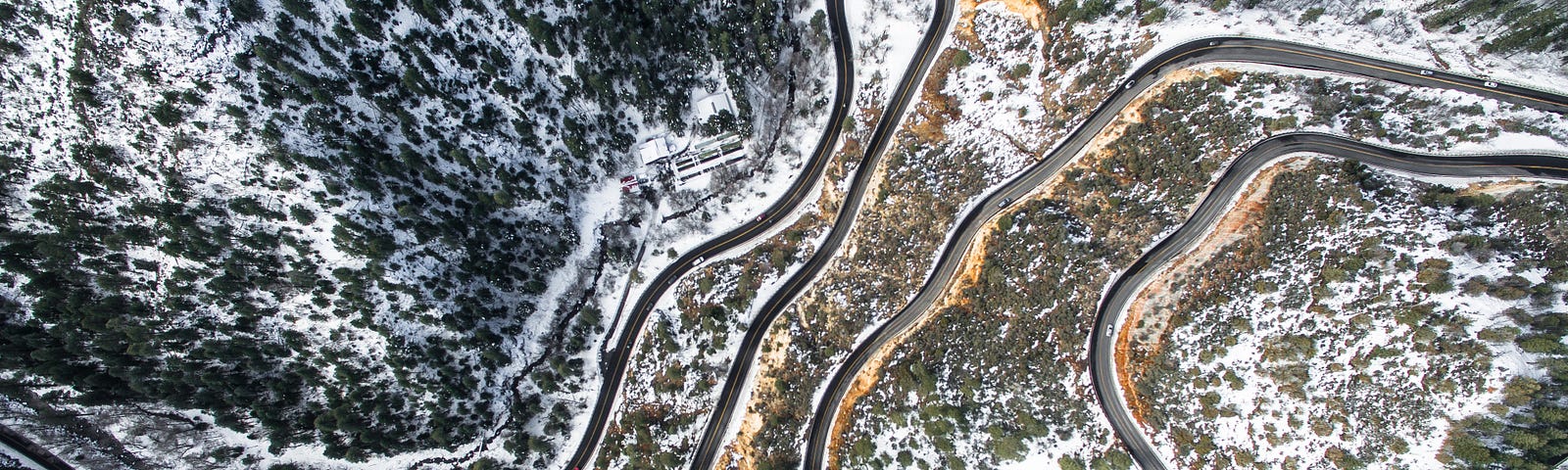 Overhead photo of a winding road through a snowy forest