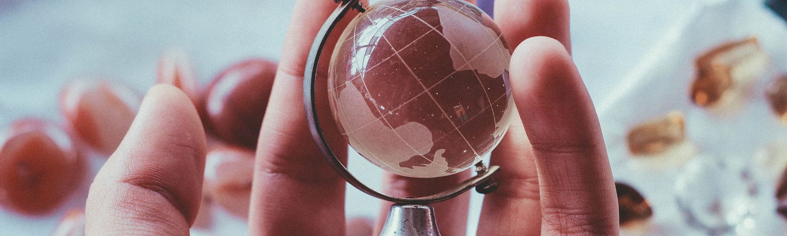 A hand holding a miniature globe implying having the whole world in his hand as the metaphorical allusion of how a billionaire views himself.