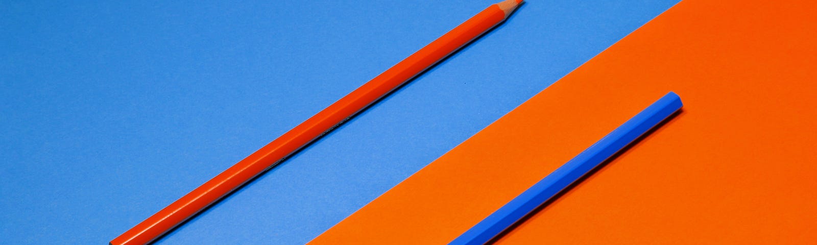 A red colored pencil on a blue background and a blue colored pencil on a red background.