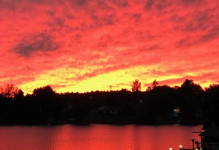 Bright red and orange sunset over lake