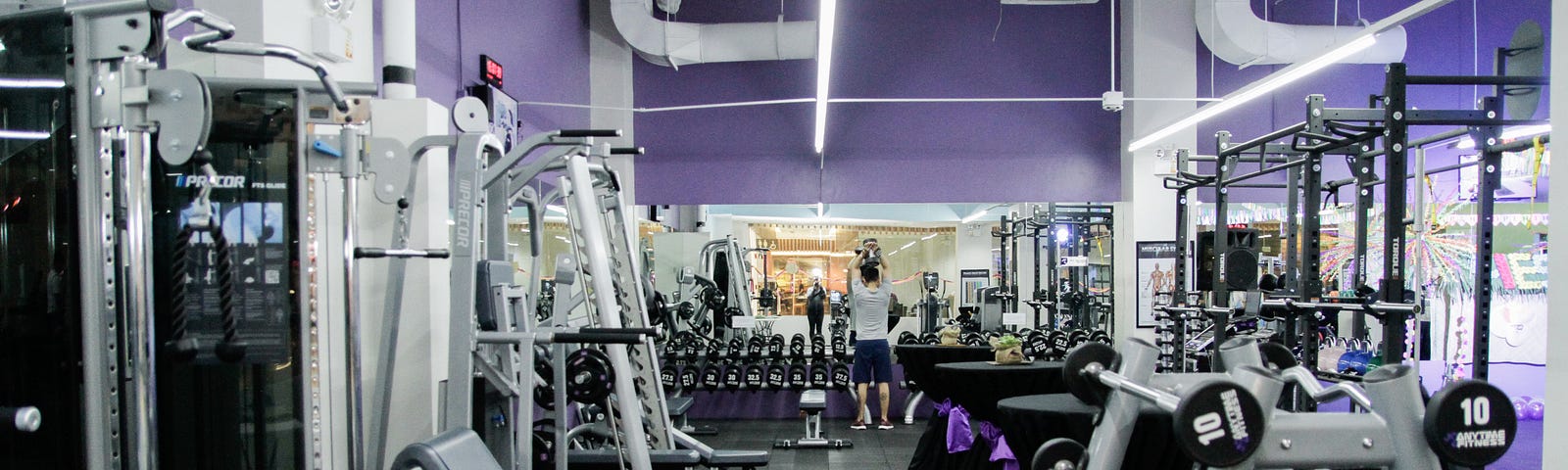 Gym equipment in a largely empty gym