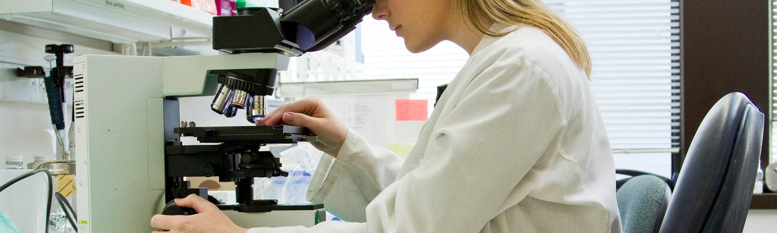 A lady scientist poring over a microscope in the lab