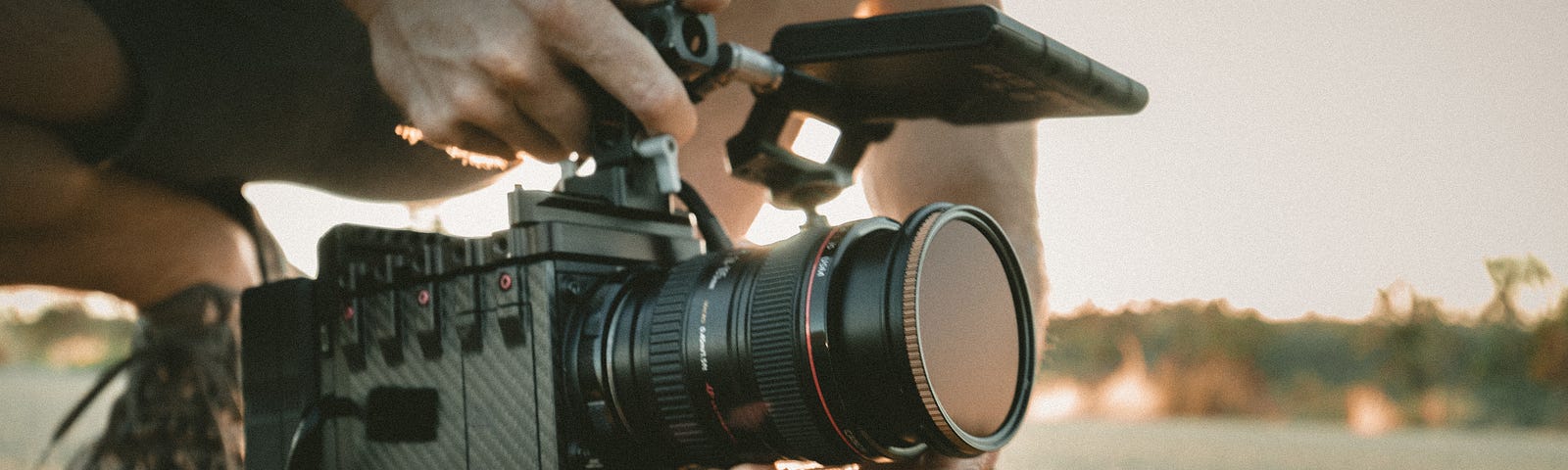 A person filming with a heavy-duty video camera set on the ground.