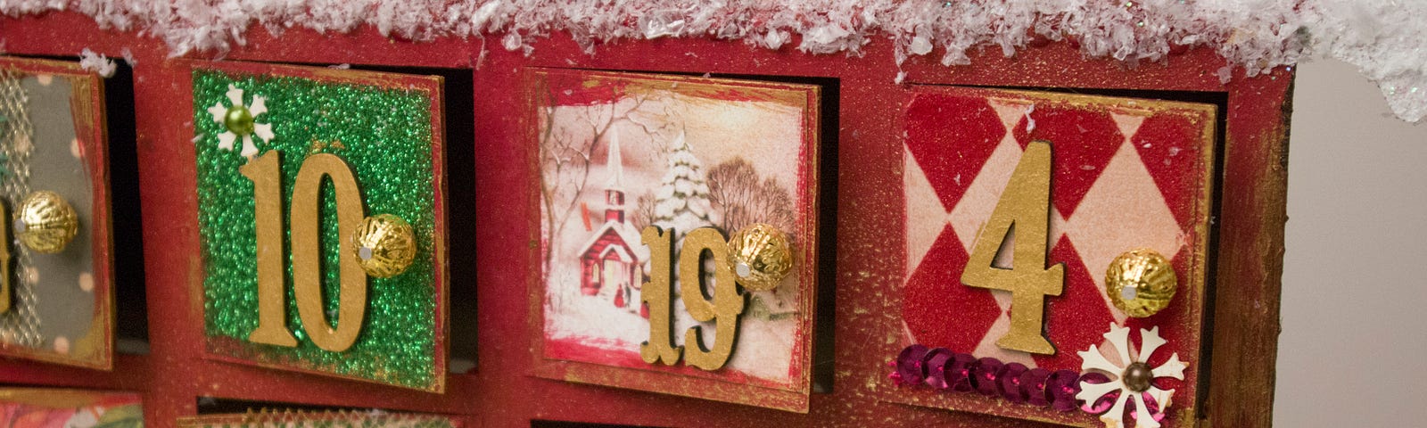 Close up of red and green wooden advent calendar with doors for every day in December