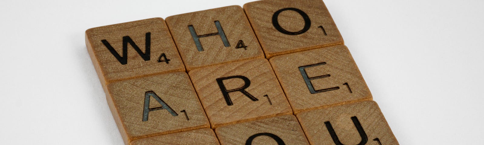 An image of Scrabble letters saying ‘who are you’, the three words displayed under each other in a square.
