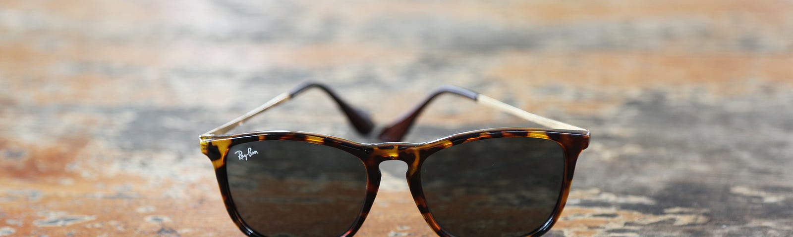 Tortoise-shell RayBan Wayfarer sunglasses, circa 1992, on a picnic table