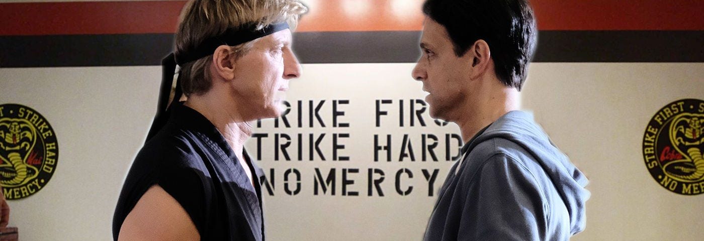 Johnny and Daniel from Cobra Kai staring at each other menacingly.