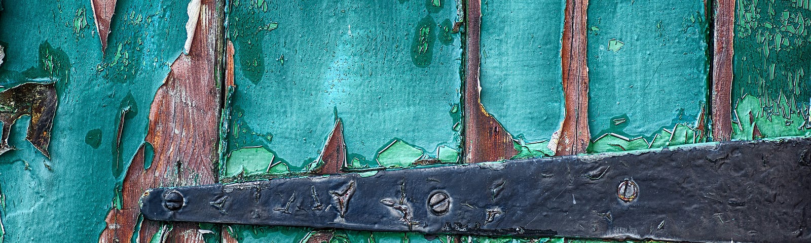 door hinge on a wooden door with teal peeling paint