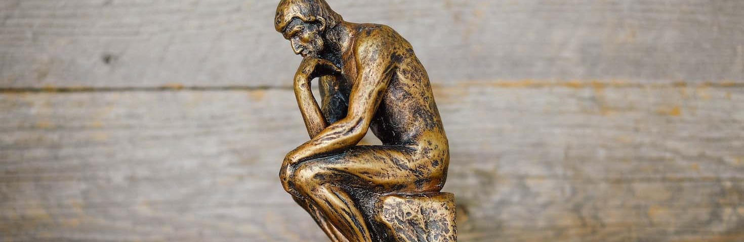 Photo of a desktop replica of the thinking man sculpture.