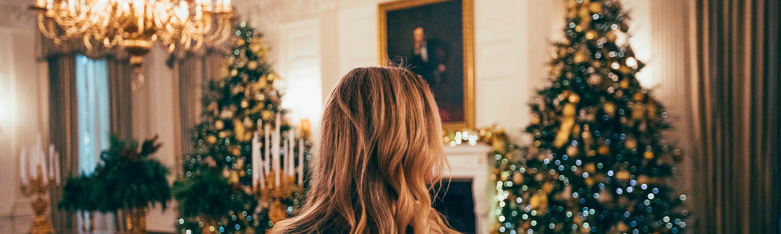 A lady looking at two Christmas trees
