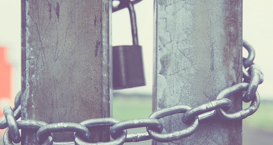 Close up of chain and padlock on metal gates