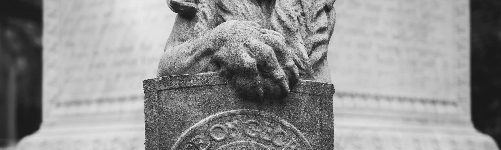 A statue of a lion holding a shield with insignia “State of Georgia“ as one of four guardians at the base of the bronze statue of the founder of the Province of the US state of Georgia in 1732, James Oglethorpe,  in Chippewa Square in Savannah, Georgia.