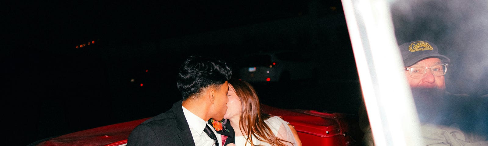 Newlyweds kissing in a car