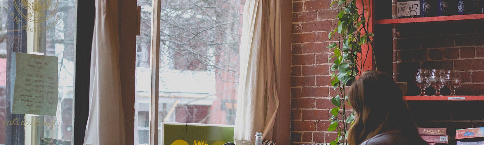 A student working alone in a coffee shop on her computer in her online class