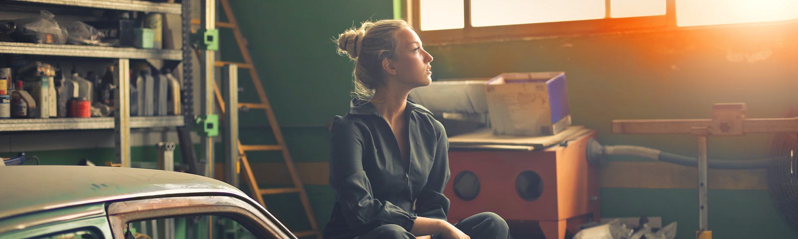 woman sitting on old car