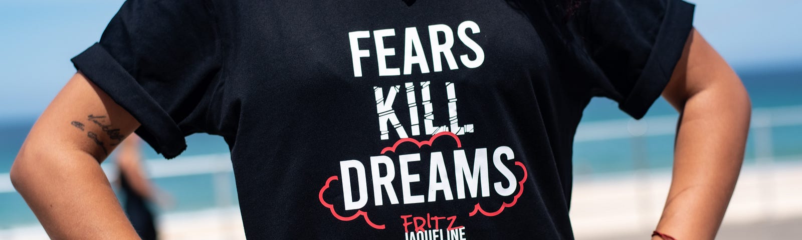 A woman wearing a black t-shirt with the text “Fears kill dreams”