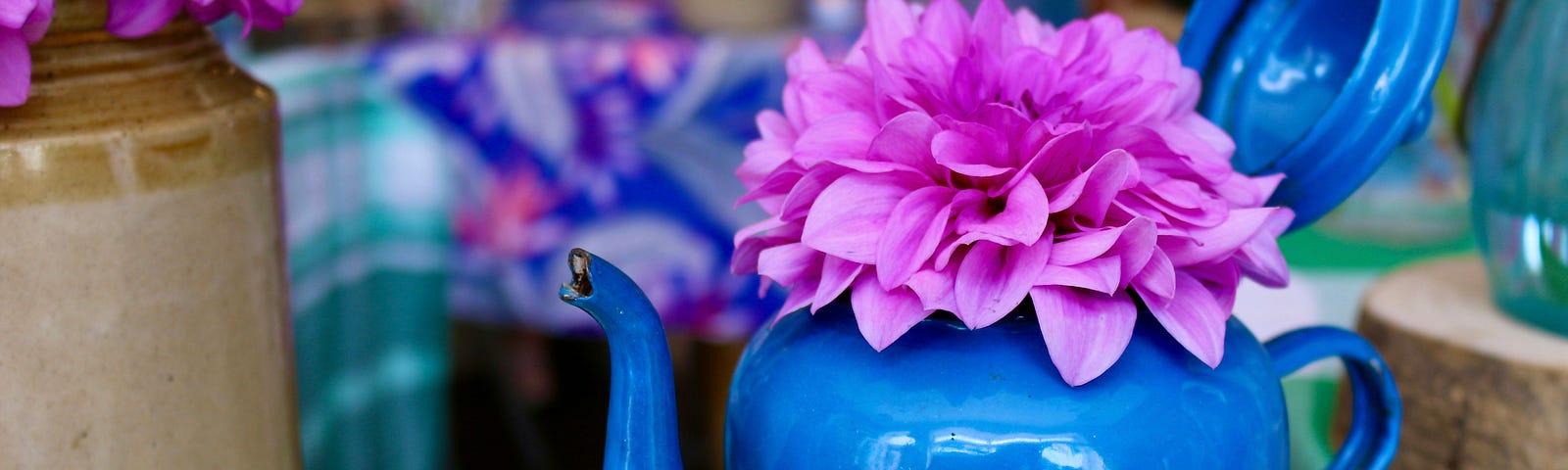 A blue teapot on a table.It reminds of simple joys in life.