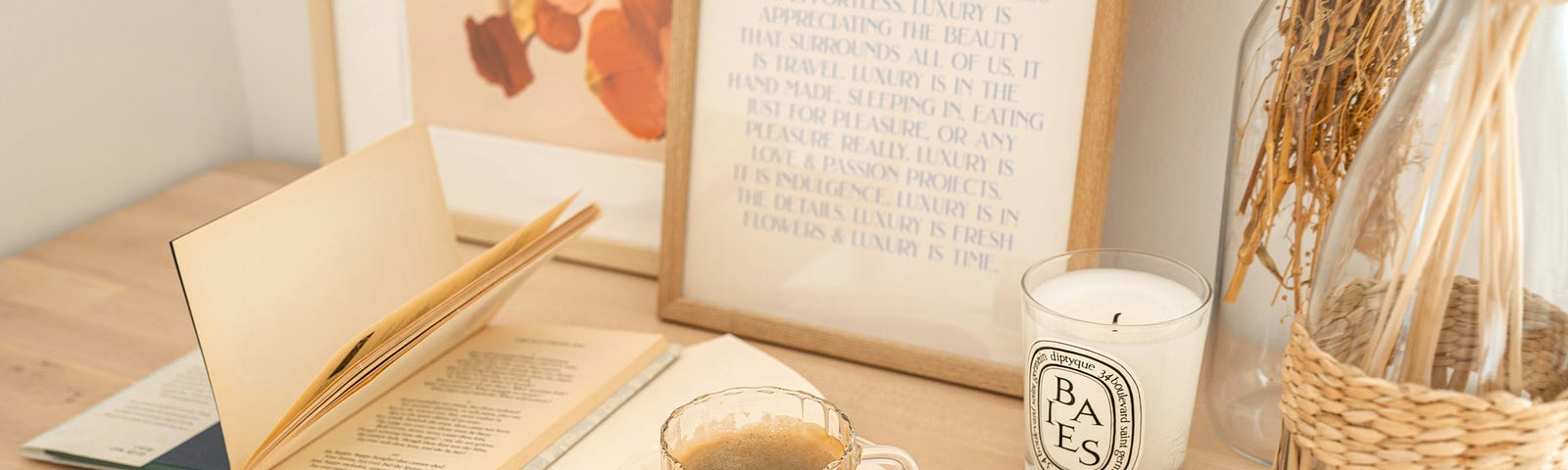 Two open books with a cup of coffee and a candle.