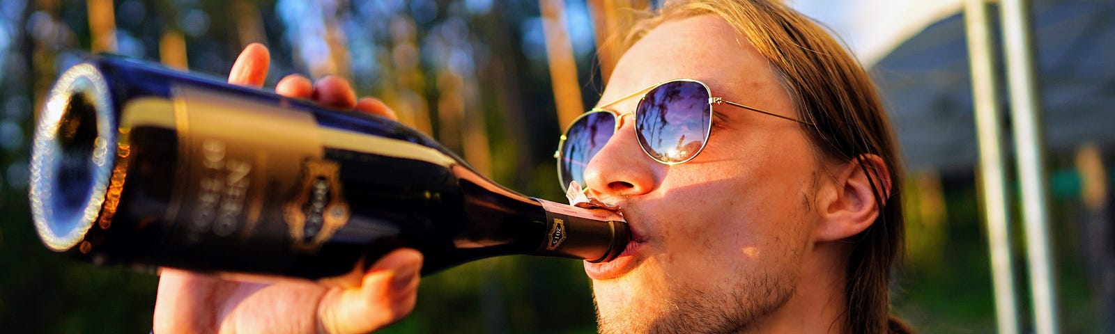 Dude drinking a bottle of beer or something.