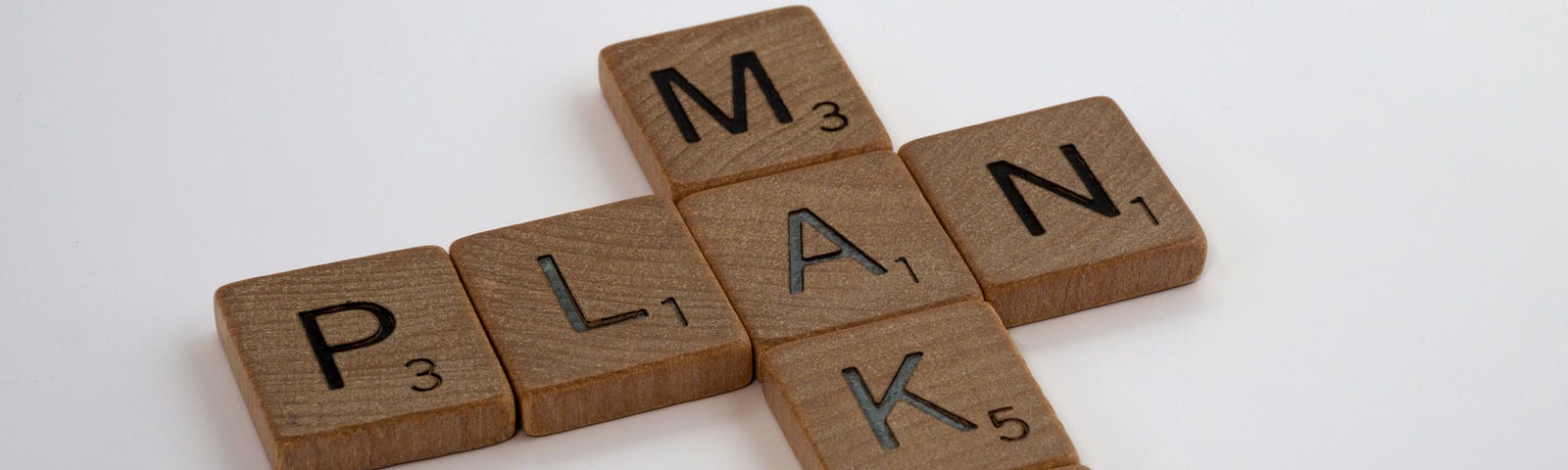 Scrabble pieces spelling out “make” and “plan”.