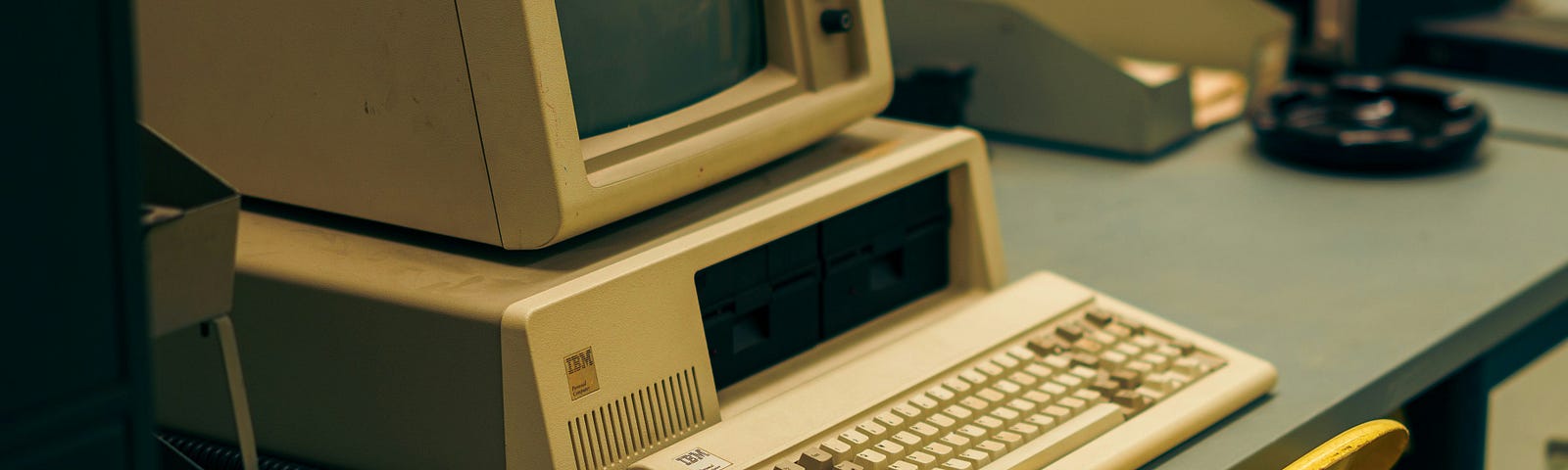 Retro desktop computer setup and paper trays on a desk