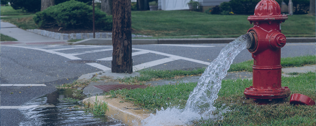 Picture showing water pouring from a broken water hydrant.