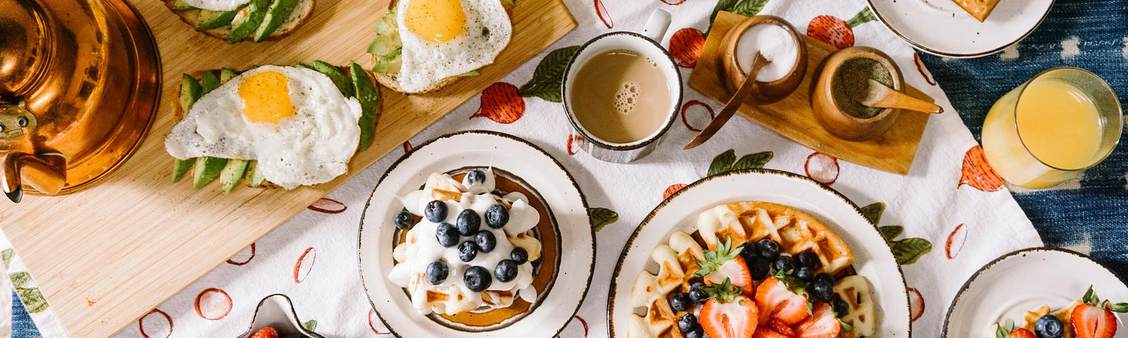 A table laden with breakfast food, juices, tea, and coffee.