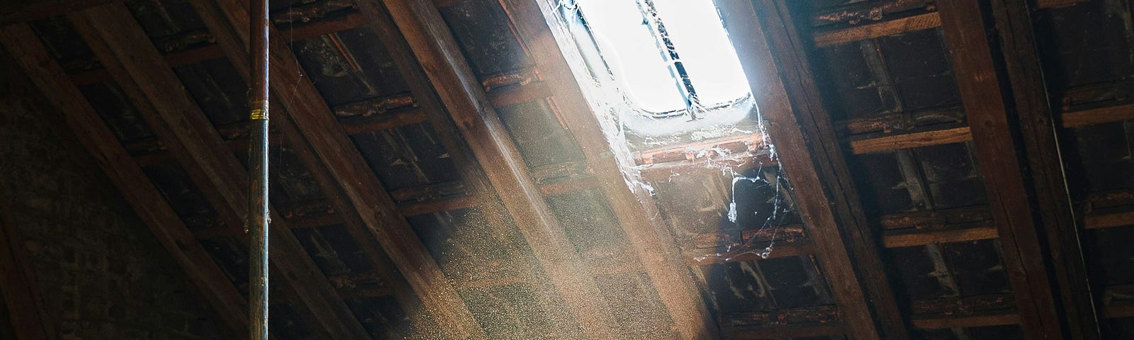 Light coming out of a window in a dusty, empty, attic